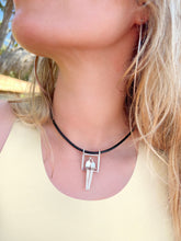 Load image into Gallery viewer, Close-up of a person wearing a necklace with a silver couple pendant outdoors