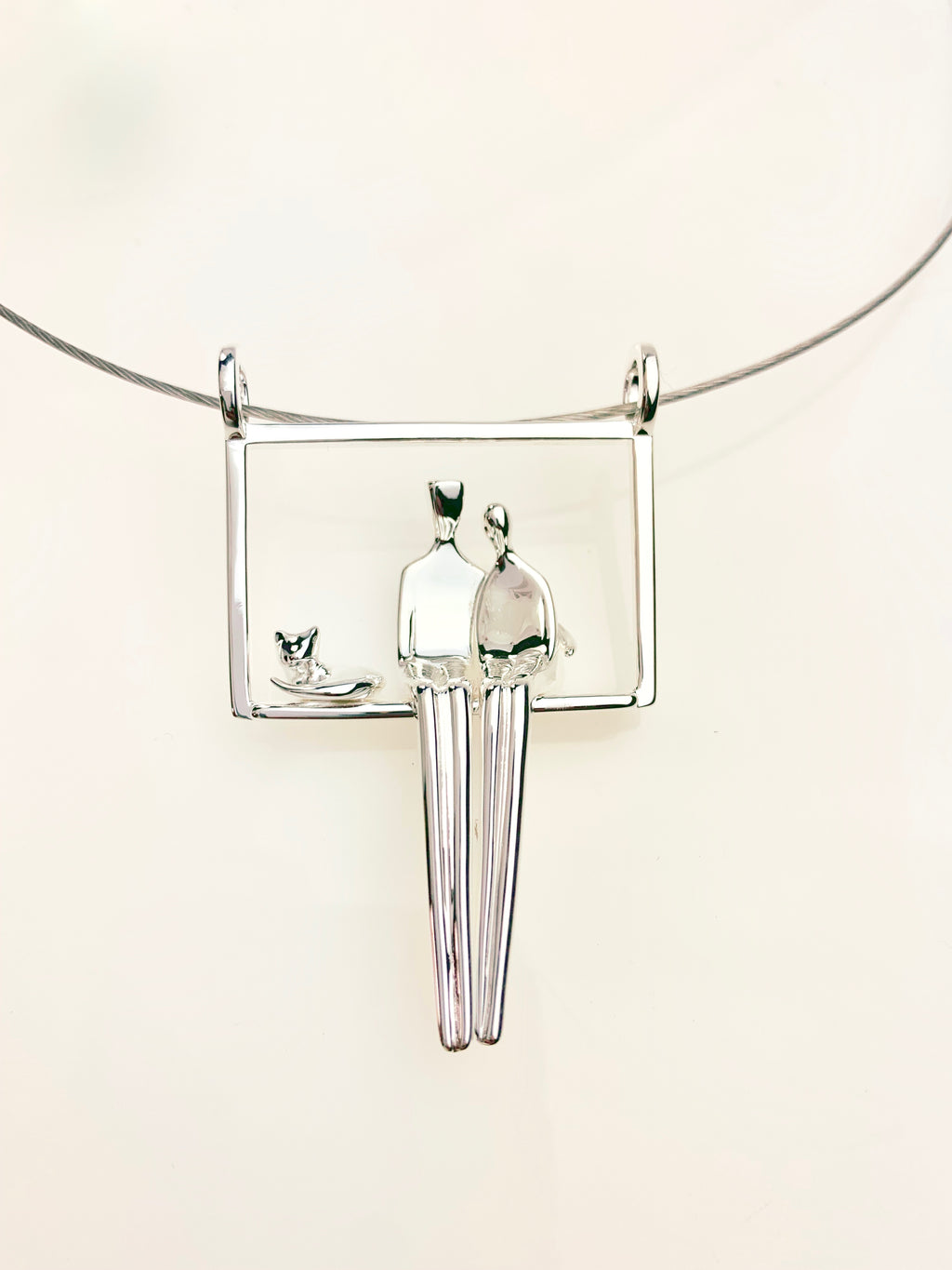 Couple with their cat pendant in silver.